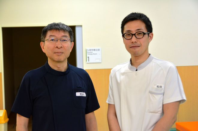 主治医であるボバース記念病院(大阪市)の荒井洋院長と作業療法士の松田大輔さん=大阪市城東区、鈴木智之撮影