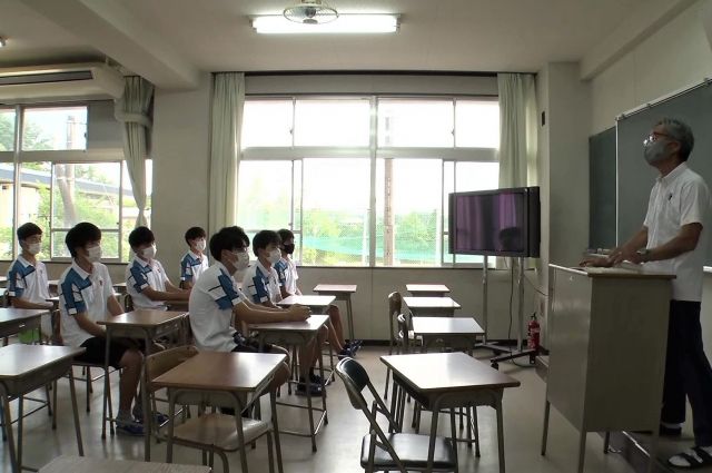平城高校テニス部の引退式で前川監督(右)の話を聞く男子部員。コロナの影響で今年は校舎内で行われた=2021年6月、奈良市朱雀の平城高校で、ブカピスタッフ撮影