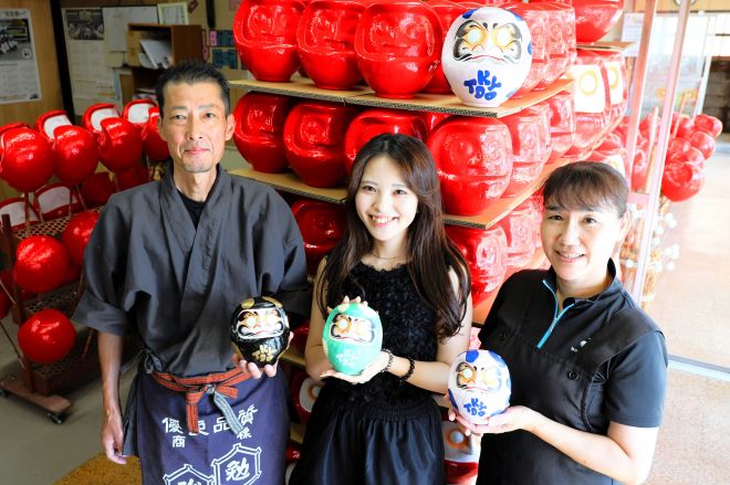 遠藤正樹さん、明子さん夫妻に囲まれる高橋史好さん=群馬県高崎市の松本商店だるま工房、友永翔大撮影