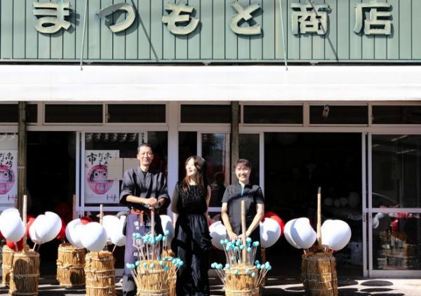 店の前で、遠藤正樹さん、明子さん夫妻と並ぶ高橋史好さん＝群馬県高崎市の松本商店だるま工房、友永翔大撮影