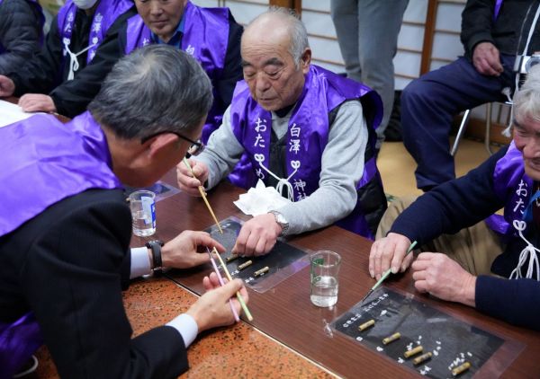 竹筒に入った米粒を数える人たち