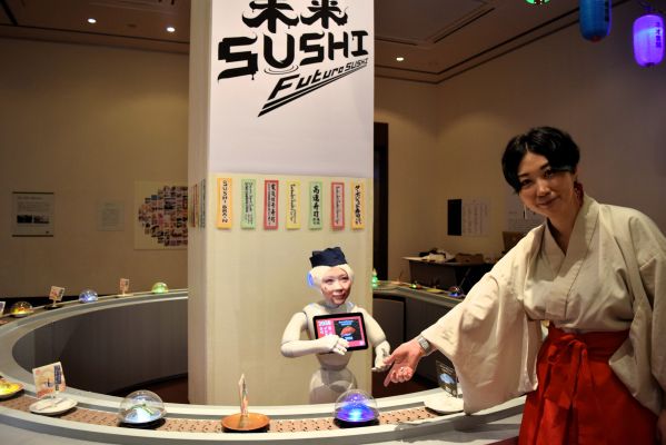 100年後の回転ずし屋をイメージした作品「未来SUSHI」（部分）。レーンを流れる、ペッパー大将が説明するネタとは……＝熊本市中央区の熊本市現代美術館
