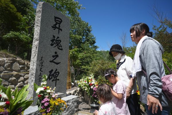 御巣鷹の尾根にある「昇魂之碑」で手を合わせる人たち=2024年8月12日午前11時40分、群馬県上野村、小林一茂撮影