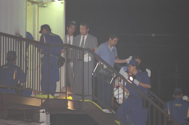 高校生2人を含む女性3人が射殺される事件が起きた「スーパーナンペイ大和田店」。2階の出入り口付近を調べる警察官たち=1995年7月、東京都八王子市