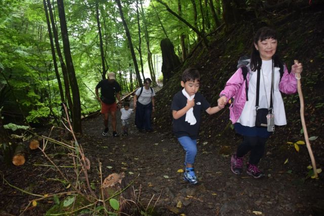事故で父を亡くした内野理佐子さん（右）。12日の慰霊登山では、娘夫婦と孫2人の3世代で慰霊登山した＝2025年8月12日、群馬県上野村、玉那覇長輝撮影