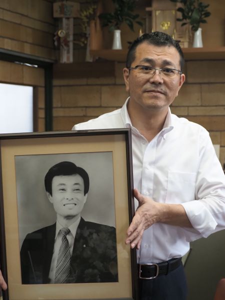 父の遺影を持つ山さん