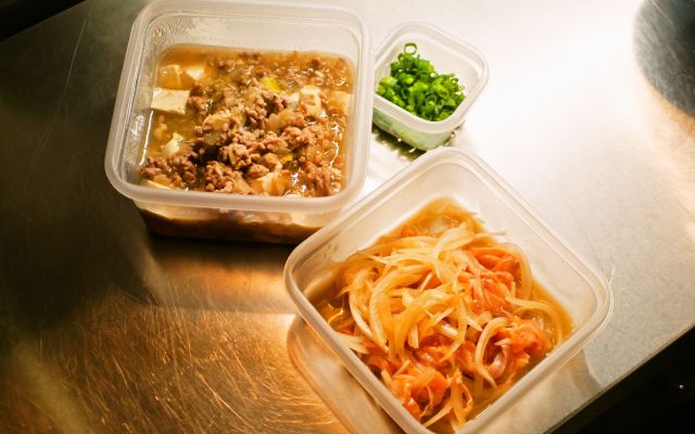 庄本さんの「はたちメシ」ふたつ。サーモンマリネの玉ねぎは、実家の畑でとれたもの。麻婆豆腐は唐辛子などを使わない、マイルドな味わい