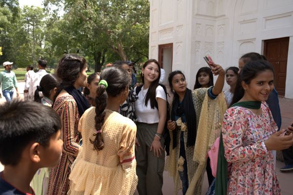 インドでの旅で、現地の人たちと写真撮影をするあんさん＝本人提供