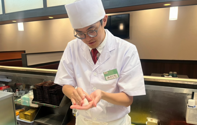 カウンターの向こうでお寿司を握る水口さん。ほかにも卵焼きの調理なども担います＝本人提供