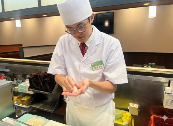 カウンターの向こうでお寿司を握る水口さん。ほかにも卵焼きの調理なども担います＝本人提供