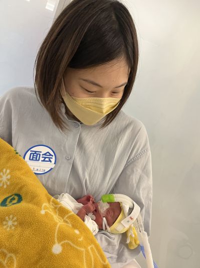 こうきさんを抱っこする内西さん（画像の一部を加工しています）