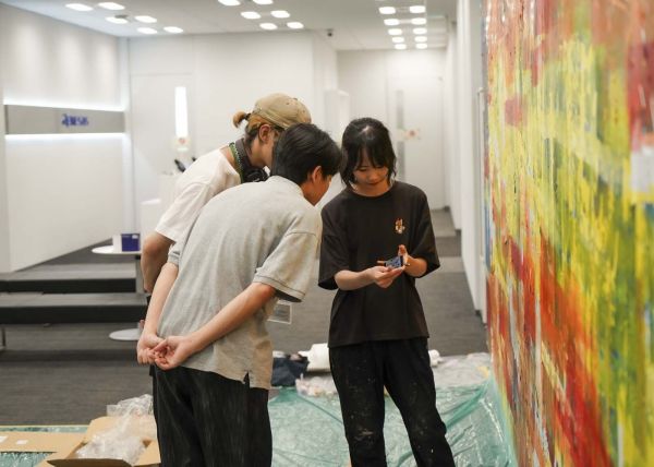 壁画を制作する中村琴梨さん(右)