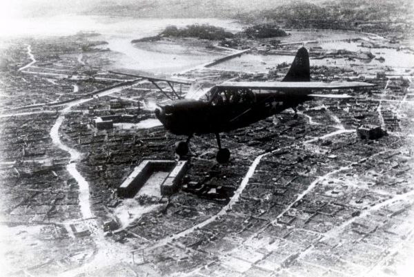 10・10空襲で焼け野原になった那覇市街の上空を飛ぶ米軍偵察機=「写真集那覇百年のあゆみ」掲載、那覇市歴史博物館所蔵