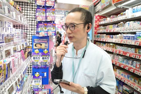 ドン・キホーテで販売登録者としてアルバイトをする、お笑いコンビ「キングマスク」の鮫島恭平さん。インカムを使って、薬の場所や在庫の有無を伝えます=筆者撮影