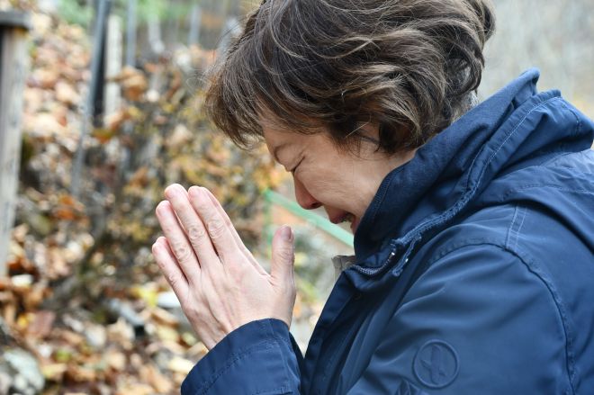 能仁千延子さんの墓標に手を合わせる山上優さん