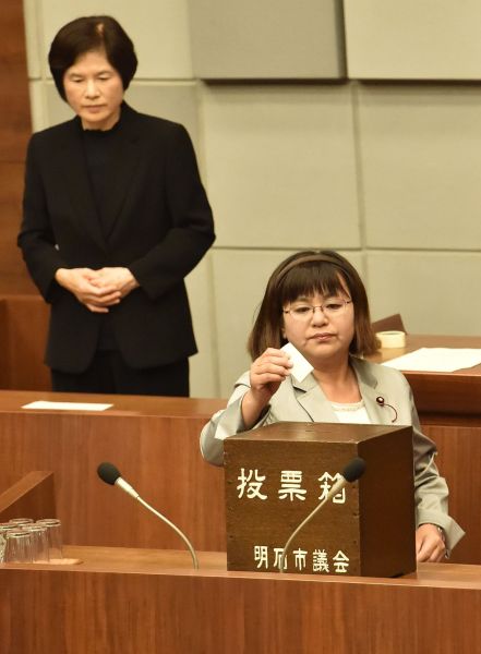 明石市議長選で投票する家根谷敦子さん（手前）。奥は手話通訳者＝2015年5月15日