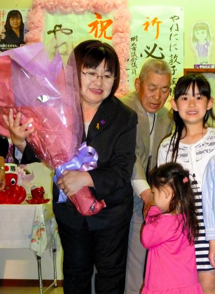 当選を決めて花束を受け取る家根谷敦子さん=2015年4月26日