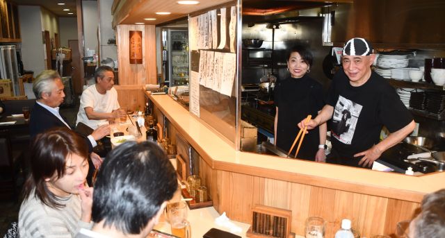 カウンターの中で料理を作る吉岡富佐男さん（手前）とかつ江さん。本間さんはいつもカウンターの左端に座っていた