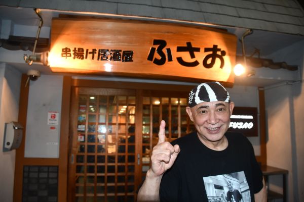 ふさおの店前でポーズを決める吉岡富佐男さん