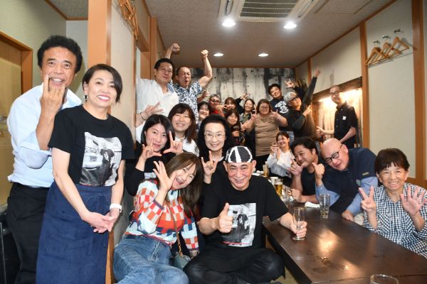 25周年パーティーで撮影した集合写真。前列中央が吉岡富佐男さん、左から2人目がかつ江さん