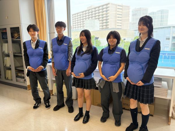 妊婦体験をする中学生たち＝2025年10月、東京都内の中学校