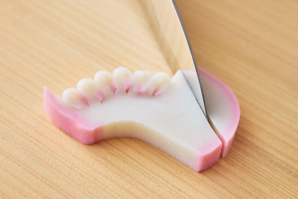かまぼこに包丁を入れて午の形を整える