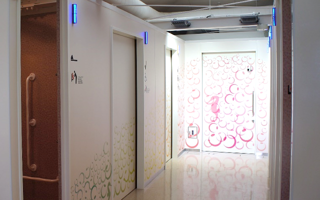 愛鷹パーキングエリアのトイレ。奥に向かって、壁の模様の色は寒色系の青から暖色系の赤に変わり、照明も明るくなっている