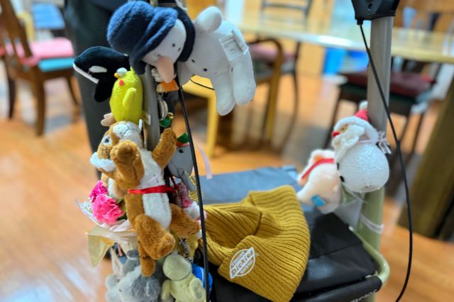 福田九右衛門さんの歩行器。ぬいぐるみが好きで、たくさんぶら下げている=2025年12月4日