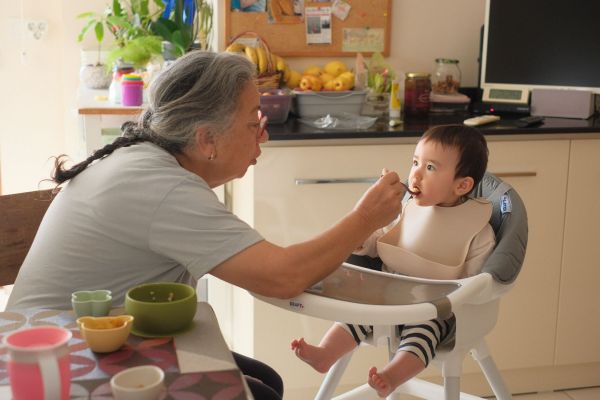 タルハナを食べさせてもらうカヤちゃん。多くの大人に関わってもらうことで、親として気づくことが多かったという