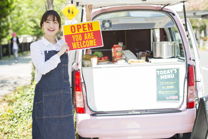 キッチンカーで呼び込みをする女性