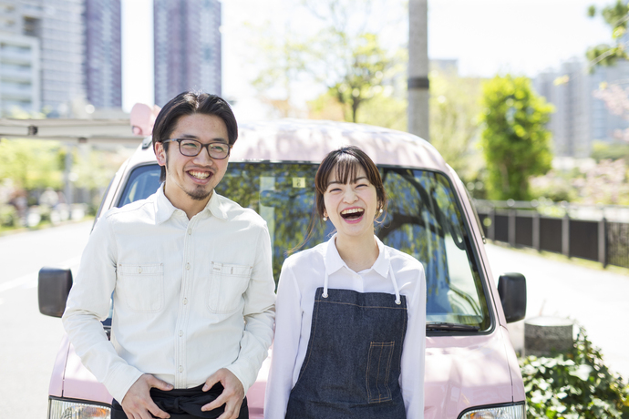 キッチンカーの前で笑う男女