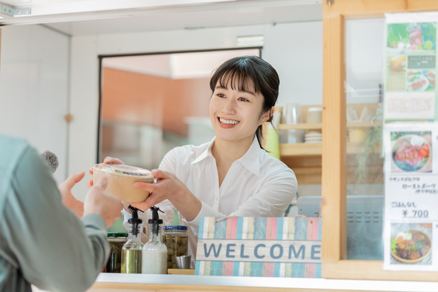 キッチンカーで接客する女性