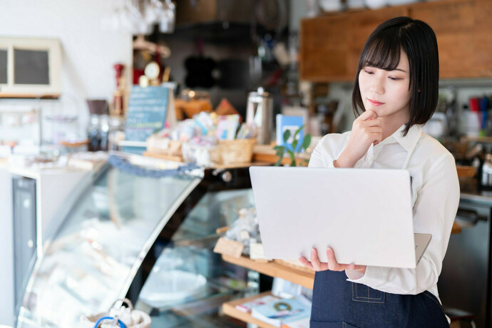 考え込む飲食店の女性
