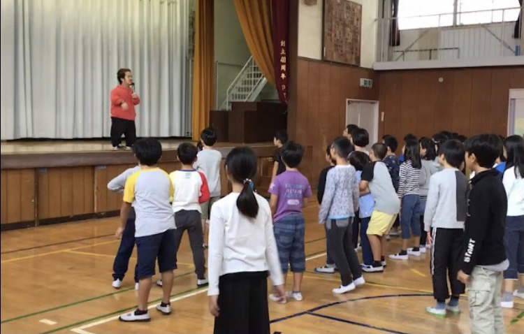 Photo of Daiki conducting a school dance workshop