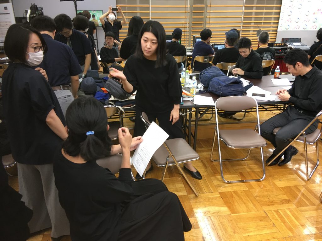 Sign language interpretation members discuss the appropriate sign translation for each scene. (Nasu, in the center)