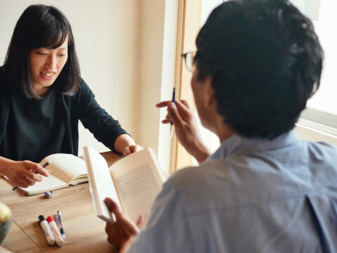 テーブルで向き合って話す男女