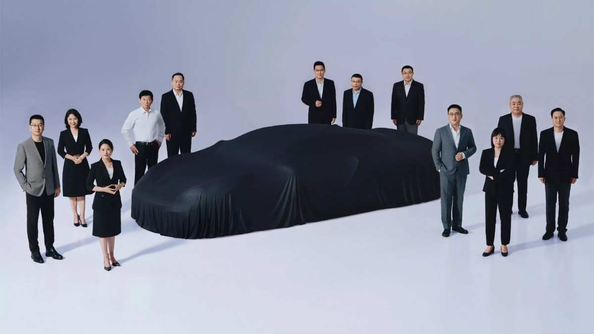 這是長城汽車董事長魏建軍於微博釋出的一張團隊合照，照片當中的車輛就是將會在2025年底推出的中置引擎超跑。