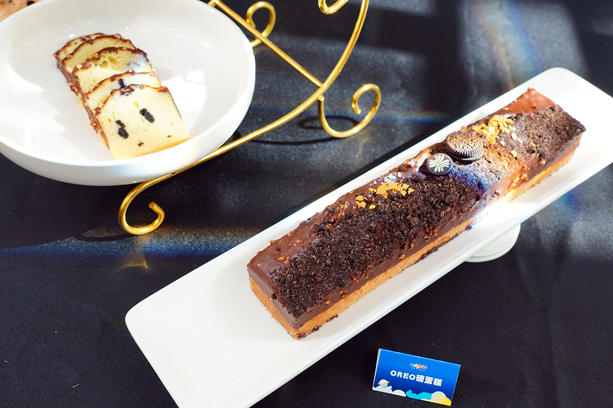 06.「OREO 磅蛋糕」將巧克力碎片融入鬆軟蛋糕體，表層則覆以巧克力淋面與杏仁角，並添上砂糖顆粒帶出層次感。