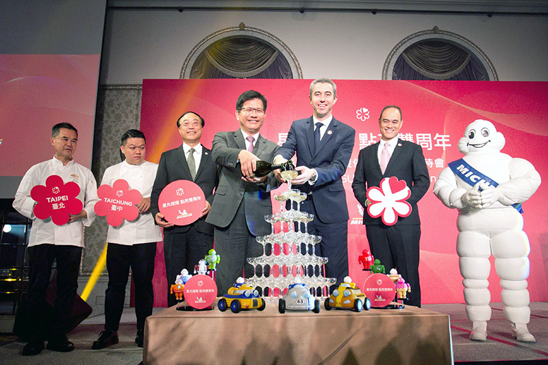 米其林指南亞洲區總監Nicolas Achard(右三)、交通部林佳龍部長(中)、交通部觀光局周永暉局長(左三)、台灣米其林輪胎毛行健董事長(右二)、Tairroir餐廳何順凱主廚(左二)、雅閣餐廳謝文主廚(左一)及米寶(右一)共同慶祝米其林指南登台兩周年。(照片提供:台灣米其林)