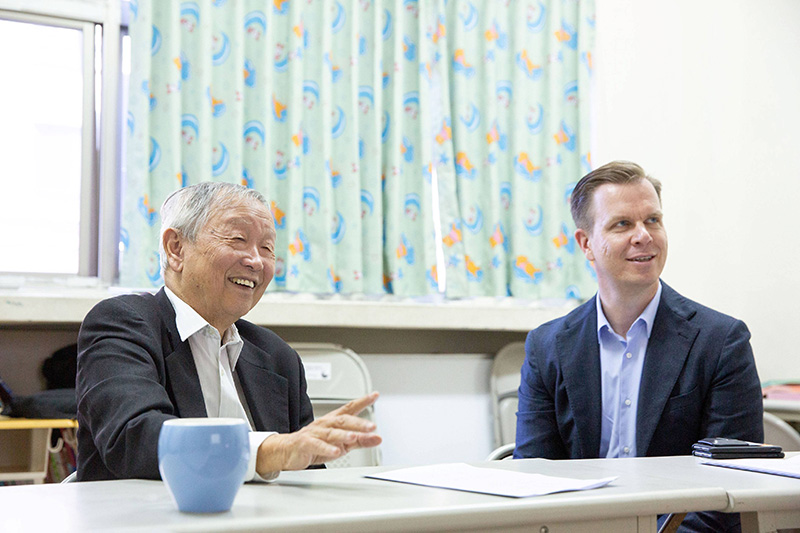 博幼基金會創辦人李家同教授(左)向台灣保時捷CEO Mathias Busse(右)介紹博幼理念與概況。