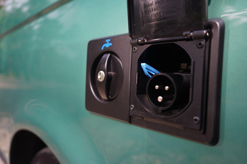 另一側則配有注水孔及外部電源插座,若營位有提供水電便無需啟動引擎即可使用車上的電器設備及水源