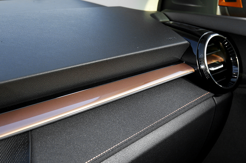 利用異材質的結合例如丹寧布搭配軟質塑料,再佐以橘色縫線及金色飾板的方式來凸顯質感