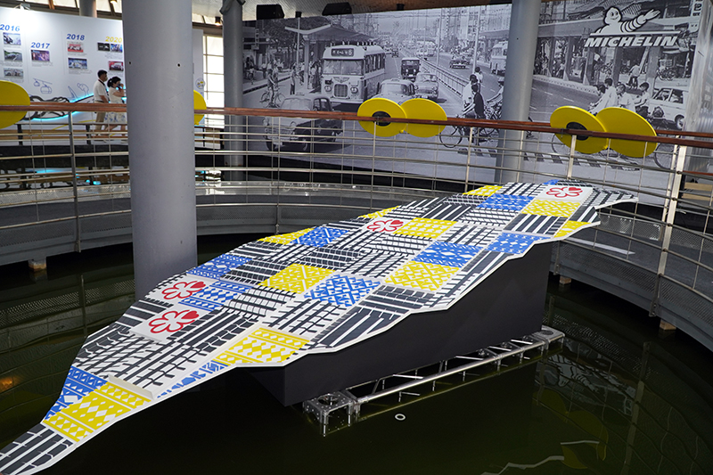 展場入口可以看見以米其林PS4 S、PS5、米其林餐廳星級符號，以及原住民圖騰所拼接的台灣地圖，象徵米其林在地深根足跡踏面全台灣。