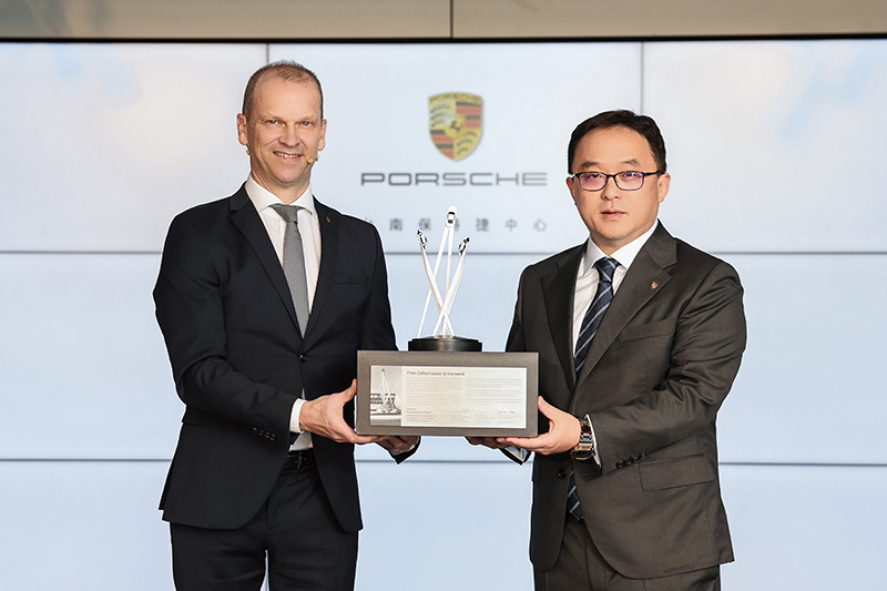 台灣保時捷總裁聶德軒 Christian Nater(左) 致贈來自德國原廠的獎牌給尚騰汽車集團執行長吳睿弘(右)。