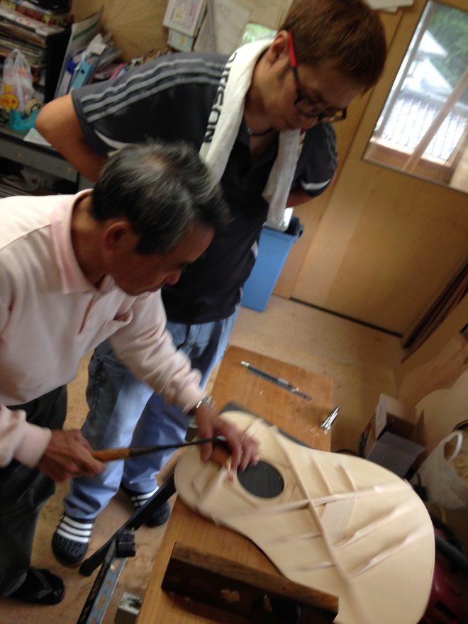 半年前から手伝いはじめたという息子さんに技術指導する辻氏。「どうしてこんなブれた写真が撮れるのか?」って?辻氏のオーラです(違