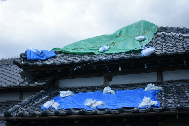 台風通過後、瓦が落ちブルーシートで覆われた「土の環」の屋根