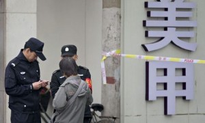 Chinese policemen check identification of a woman